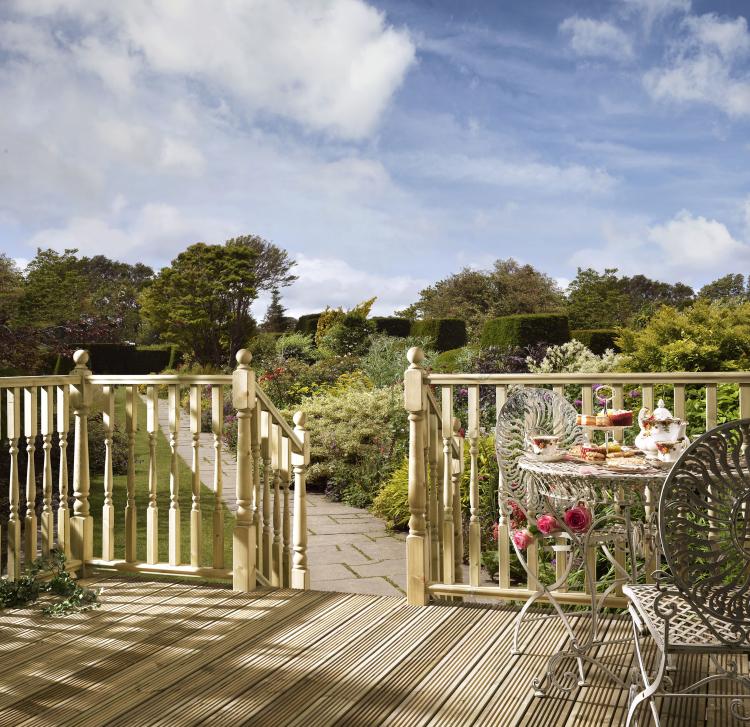 Turned Decking Balustrade product lifestyle image on a sunny day. The decking has been treated using the best decking oil products.