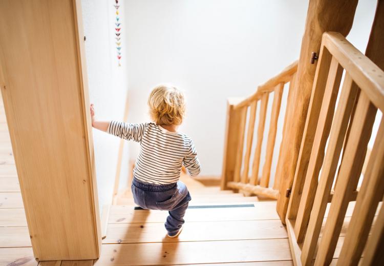 A small child walking down a staircase.