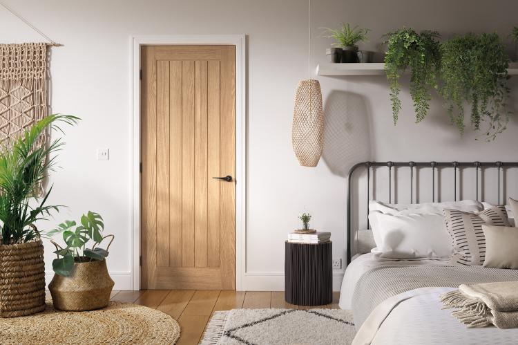 A picture of a glazed interior oak door in a home setting with modern door furniture.